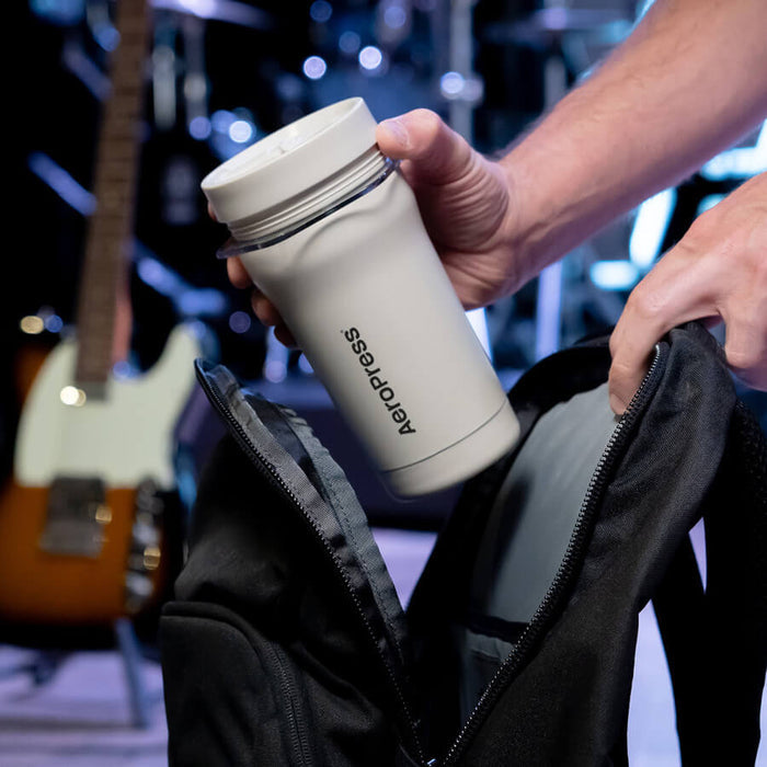 AeroPress Coffee Maker - Go Plus in cream being laced inside a backpack
