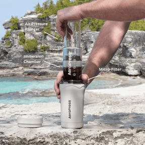 AeroPress Coffee Maker - Go Plus in Cream being used at the beach