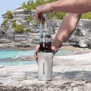 AeroPress Coffee Maker - Go Plus in Cream being used at the beach